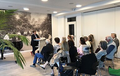 Foto: Zuschauer_innen hören einer Rednerin zu