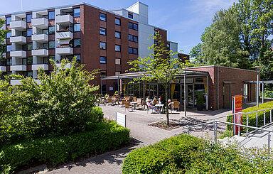 Foto: eine Sonnenterrasse mit Tischen und Stühlen vor einem Pavillon