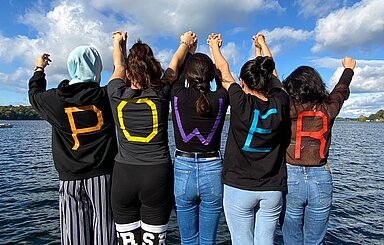 Foto fünf junge Frauen haben die Buchstaben des Worts Power auf ihren Rücken